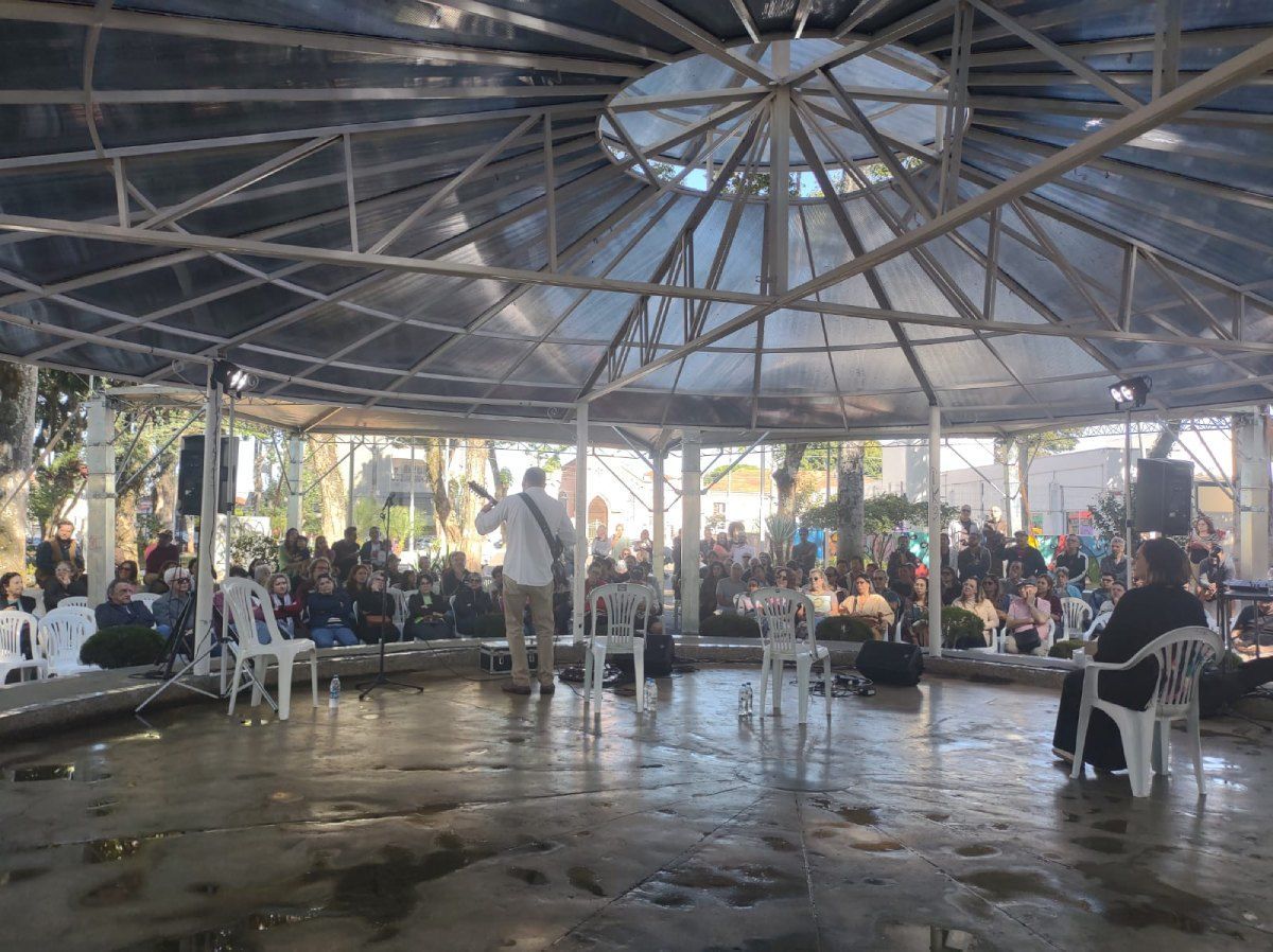 Um grupo de pessoas está sentado sob uma tenda.