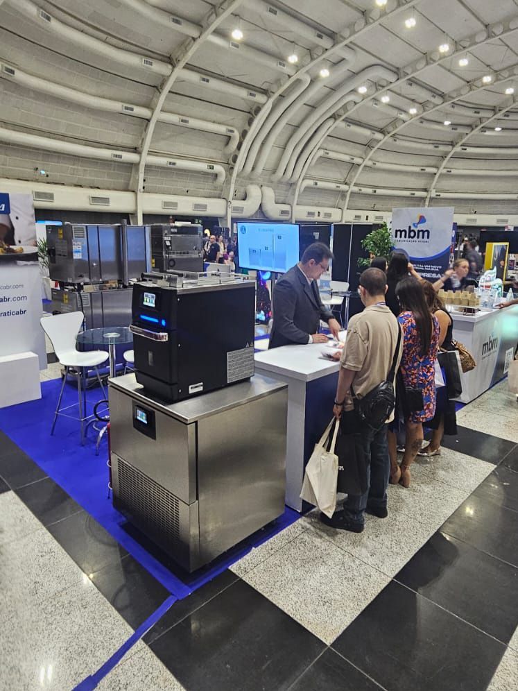 Um grupo de pessoas está em volta de um balcão em uma convenção.