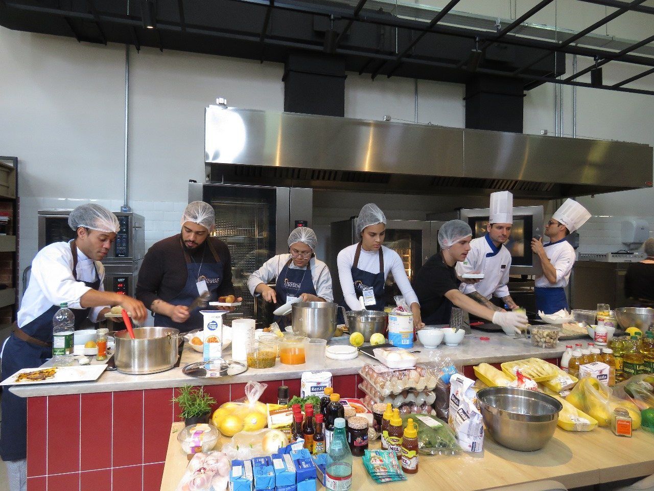 Um grupo de chefs está preparando comida em uma cozinha