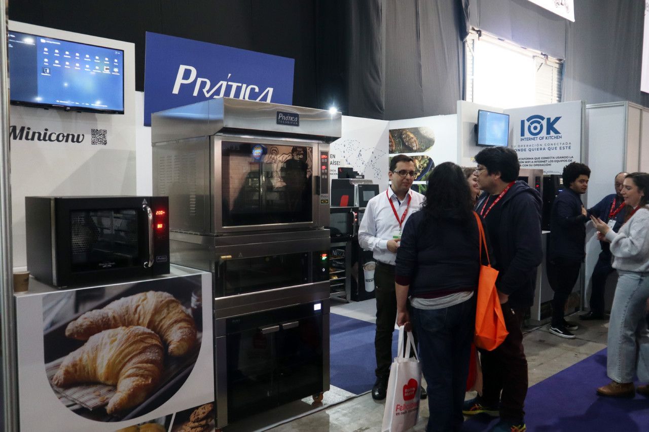 Um grupo de pessoas está em volta de uma barraca em uma padaria.