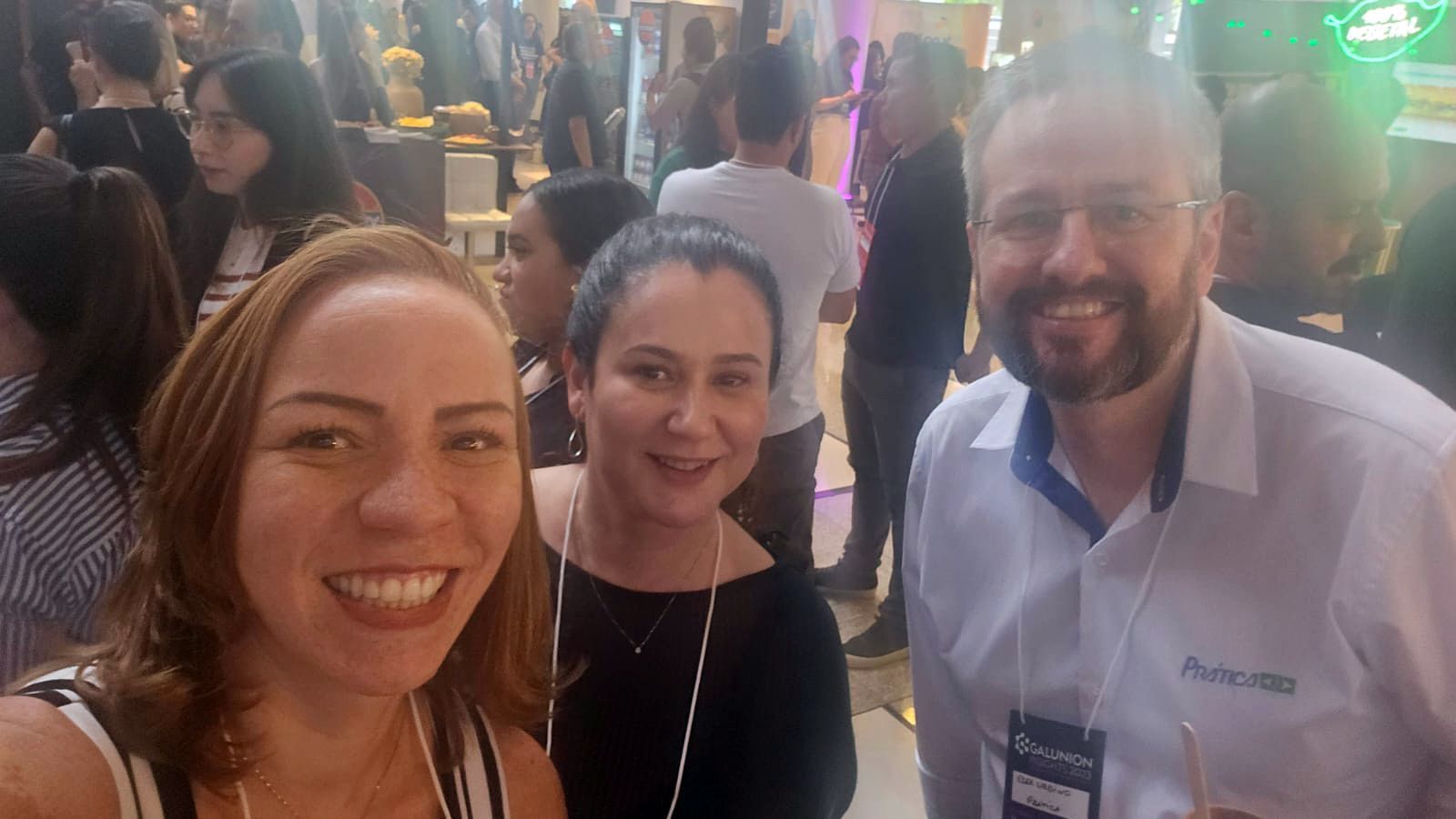 Um grupo de pessoas está posando para uma foto em uma sala lotada.