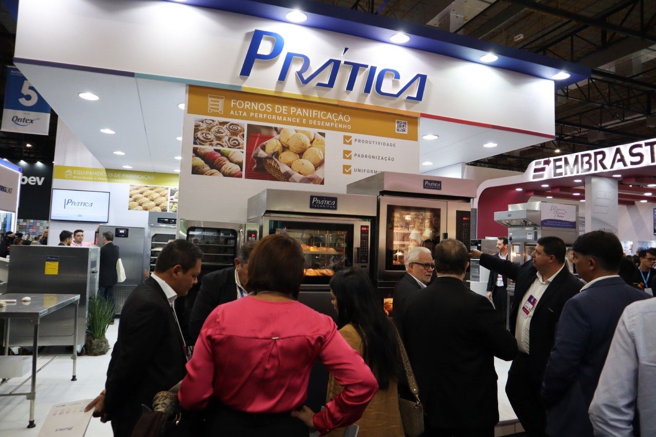 Um grupo de pessoas em pé em frente a uma placa que diz pratica