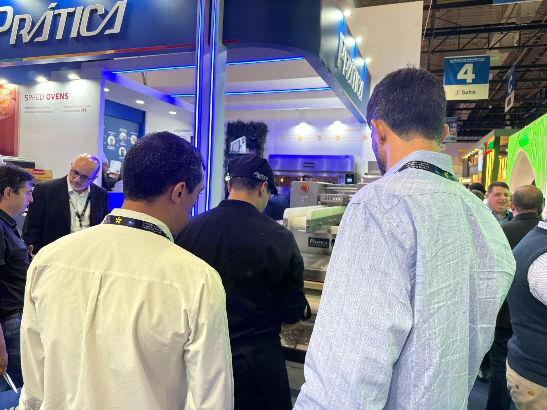 Um grupo de homens está em frente a um estande em uma convenção.