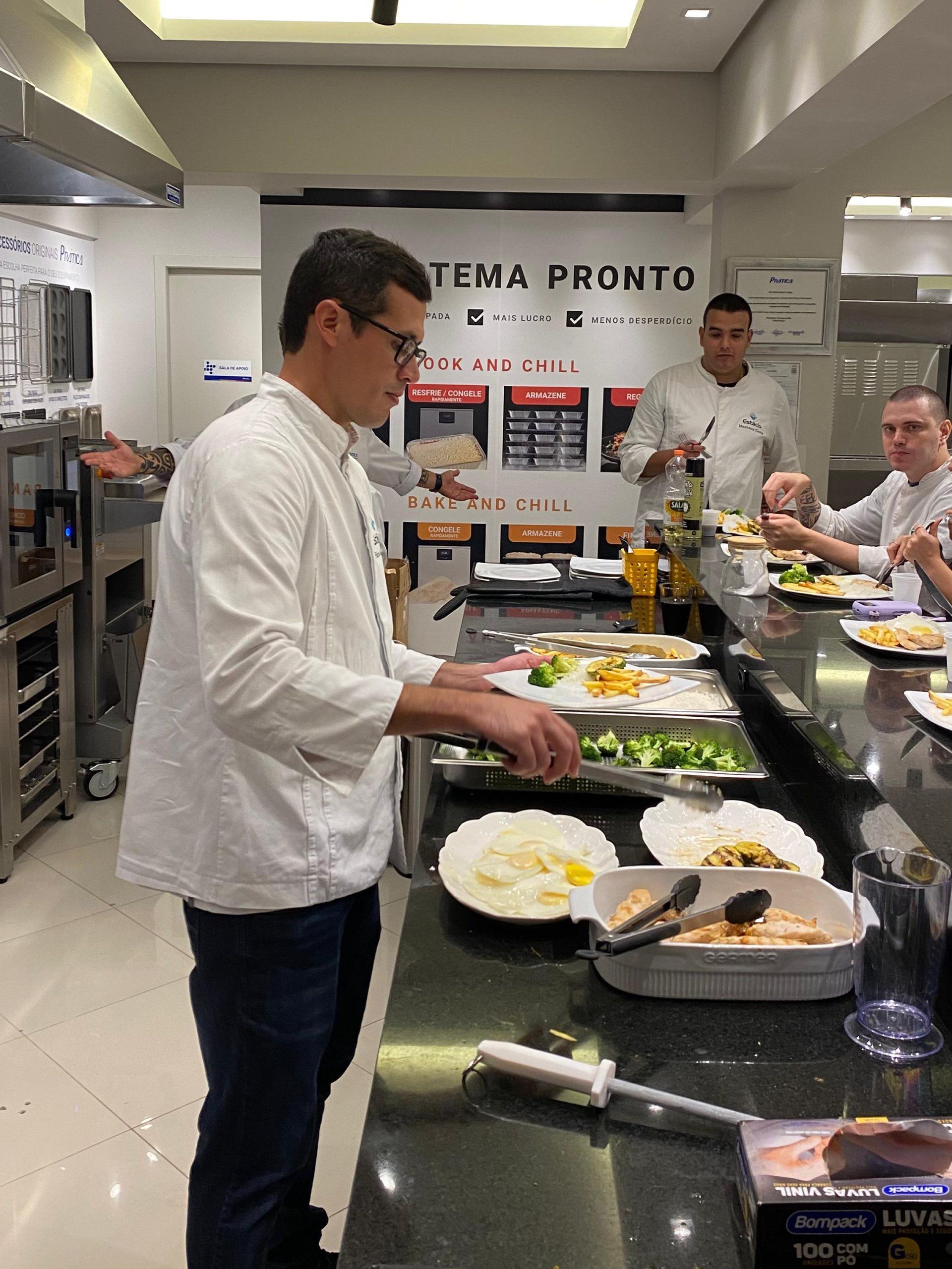 Um homem de jaleco branco está preparando comida na cozinha