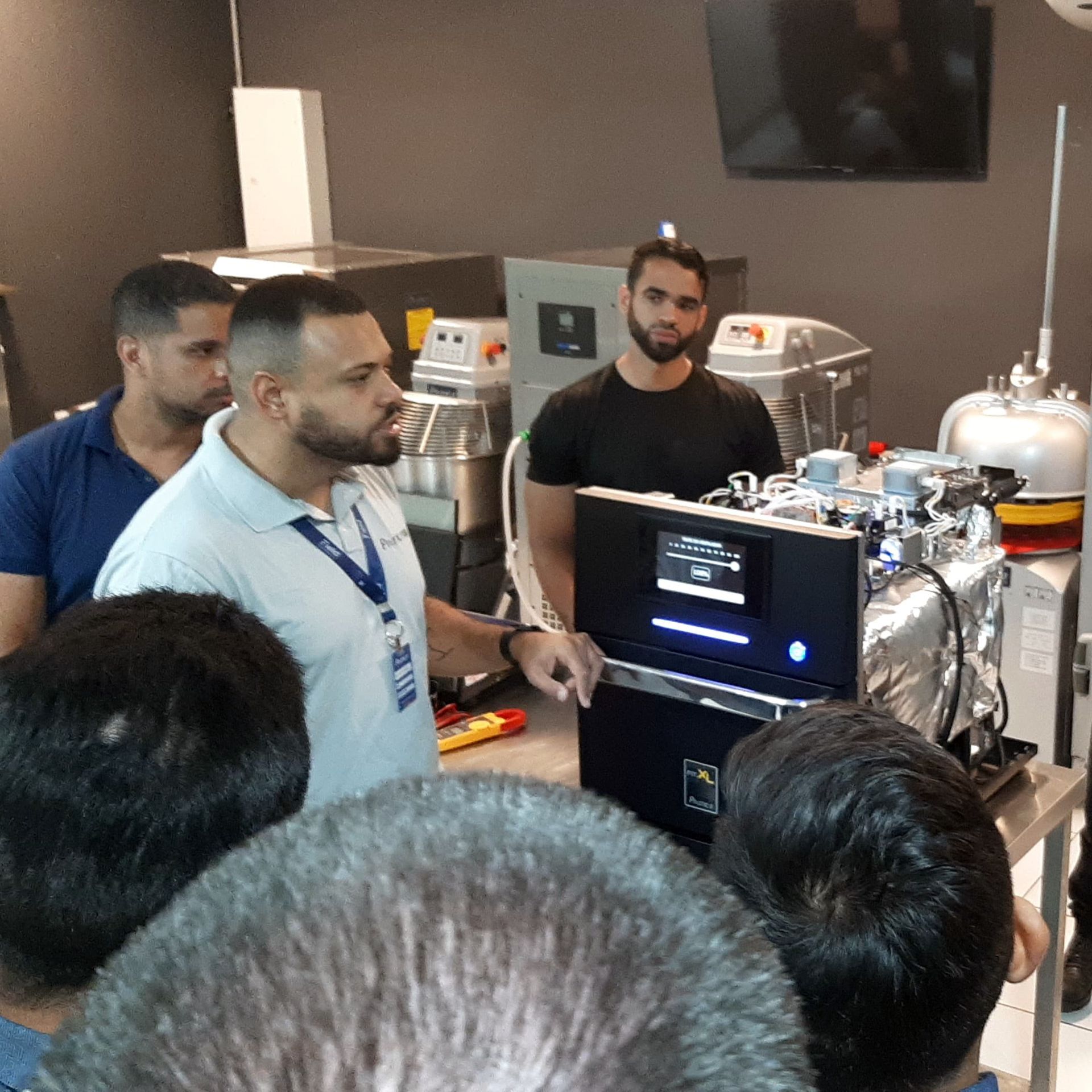 Um grupo de homens está em volta de uma máquina em uma sala.