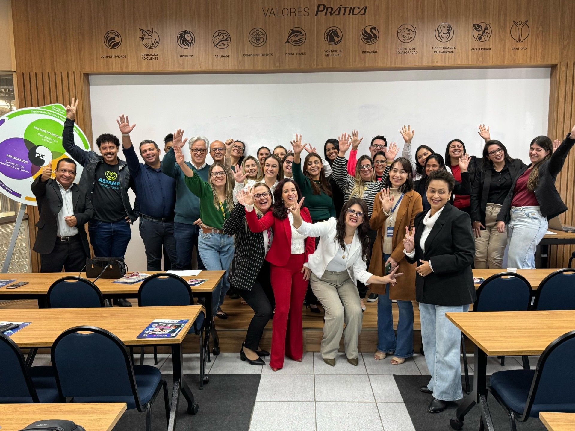 Um grupo de pessoas está posando para uma foto em uma sala de aula.