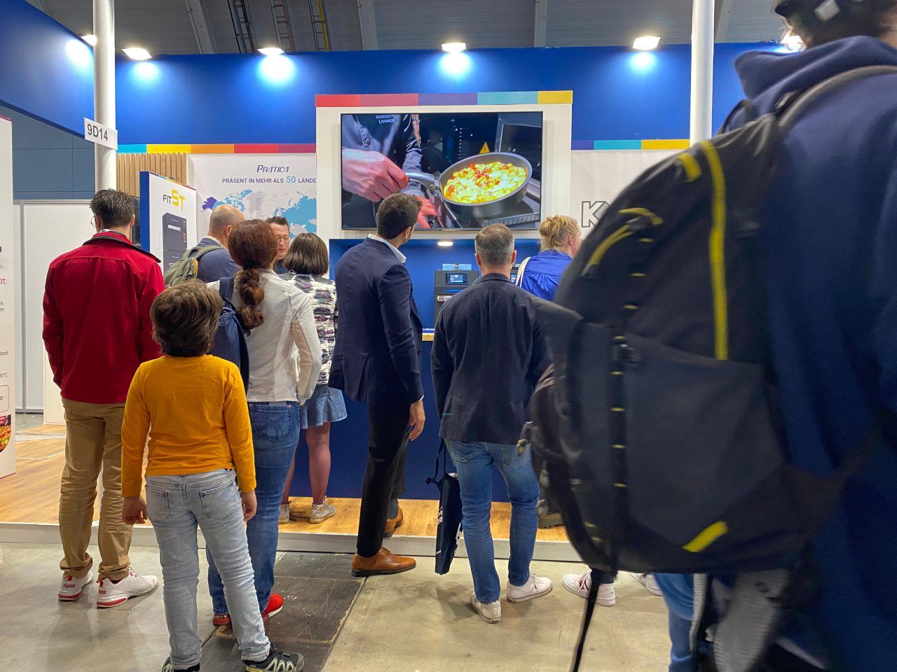 Um grupo de pessoas está em uma sala olhando para uma tela.