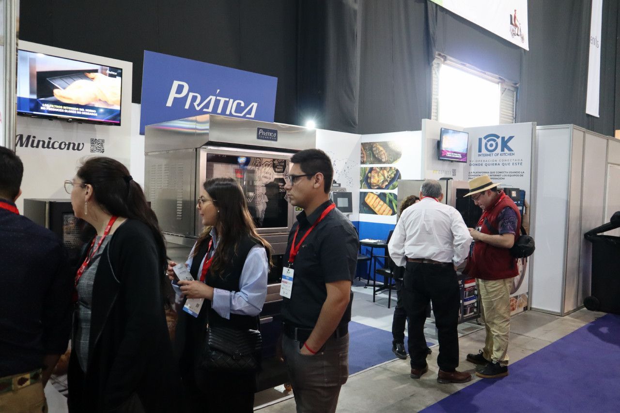 Um grupo de pessoas está em volta de um estande em uma convenção.