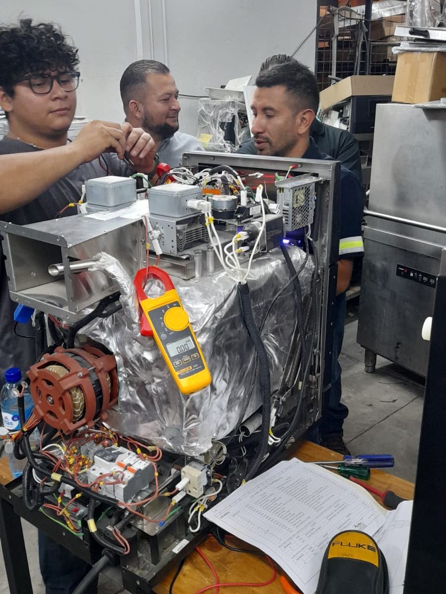 Um grupo de homens está trabalhando em uma máquina em uma cozinha.