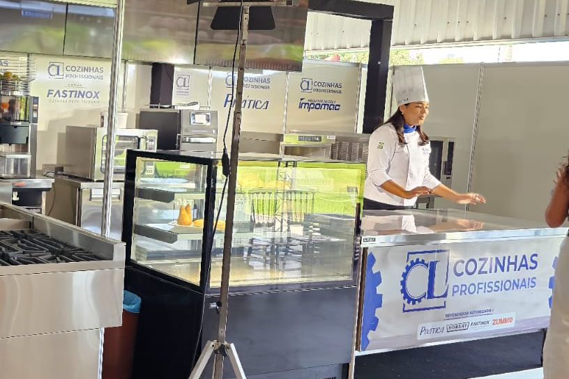 Um chef está de pé atrás de um balcão em uma cozinha.