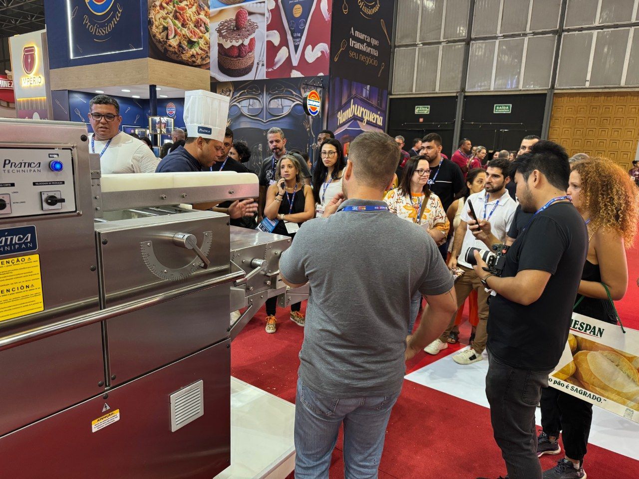 Um grupo de pessoas está em volta de uma máquina em uma sala.