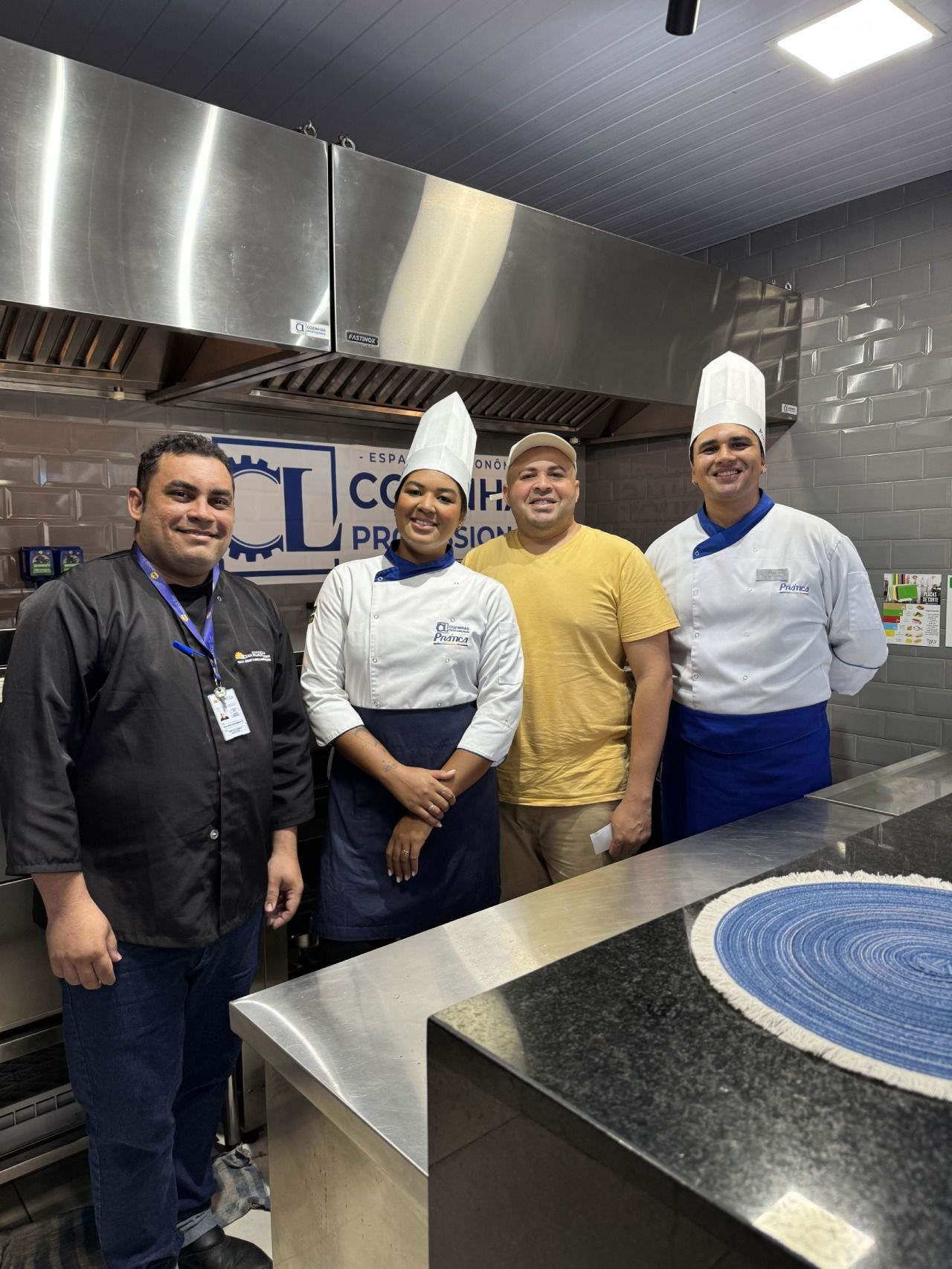 Um grupo de chefs está posando para uma foto em uma cozinha.
