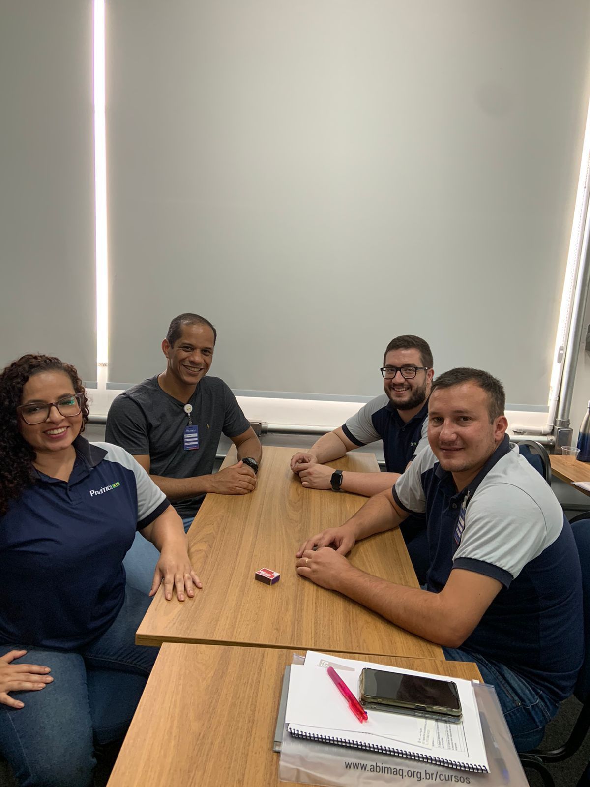 Um grupo de pessoas está sentado à mesa em uma sala.