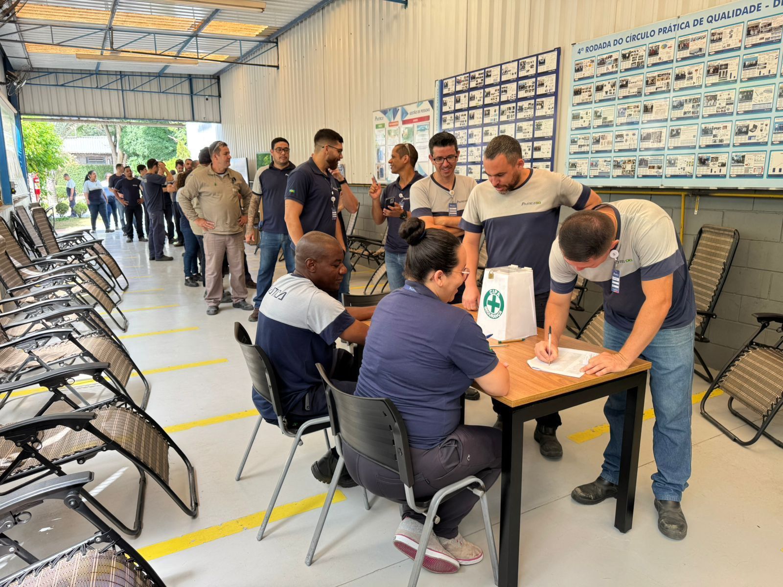 Um grupo de pessoas está sentado à mesa em uma sala.