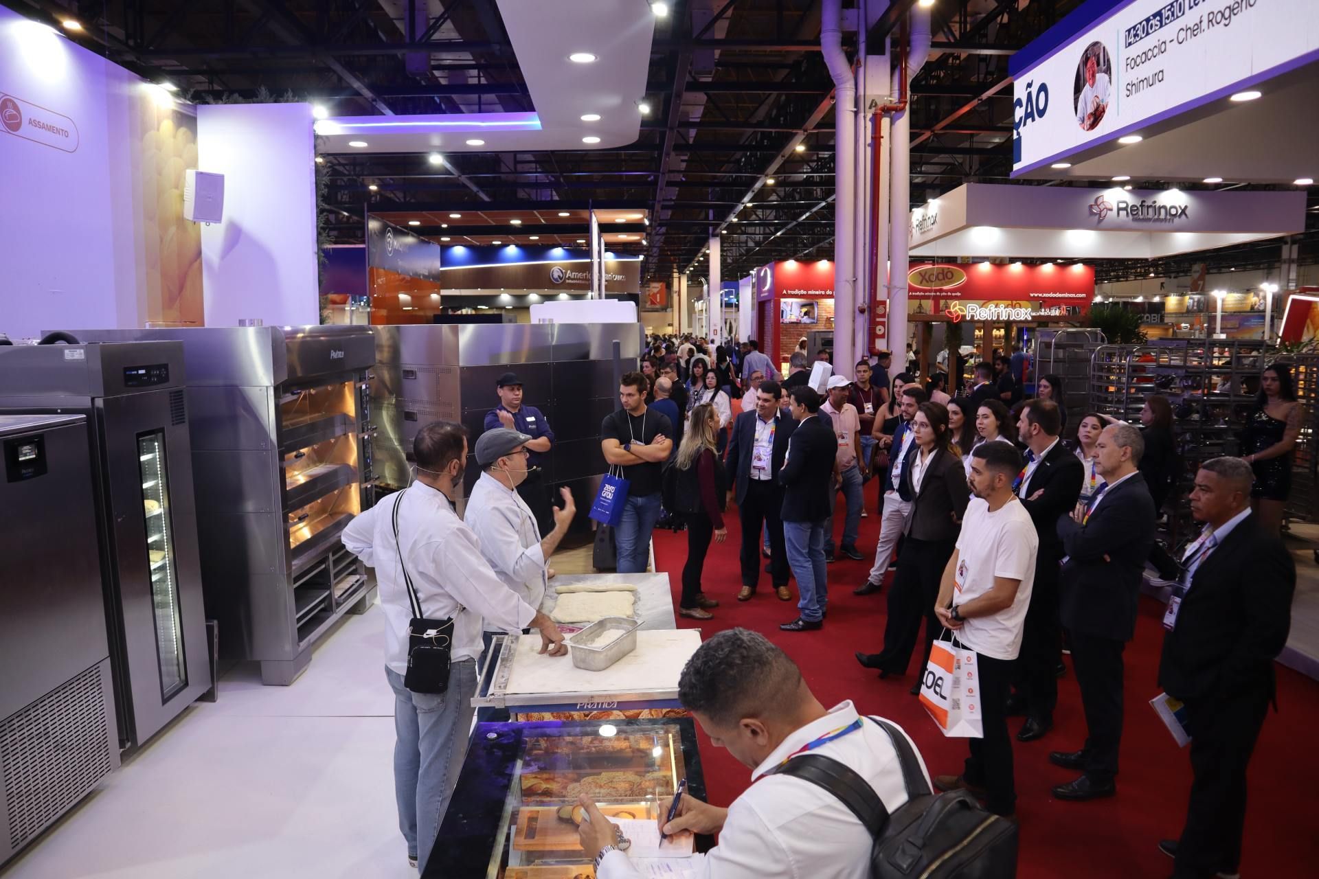 Um grupo de pessoas está em uma sala em uma convenção.