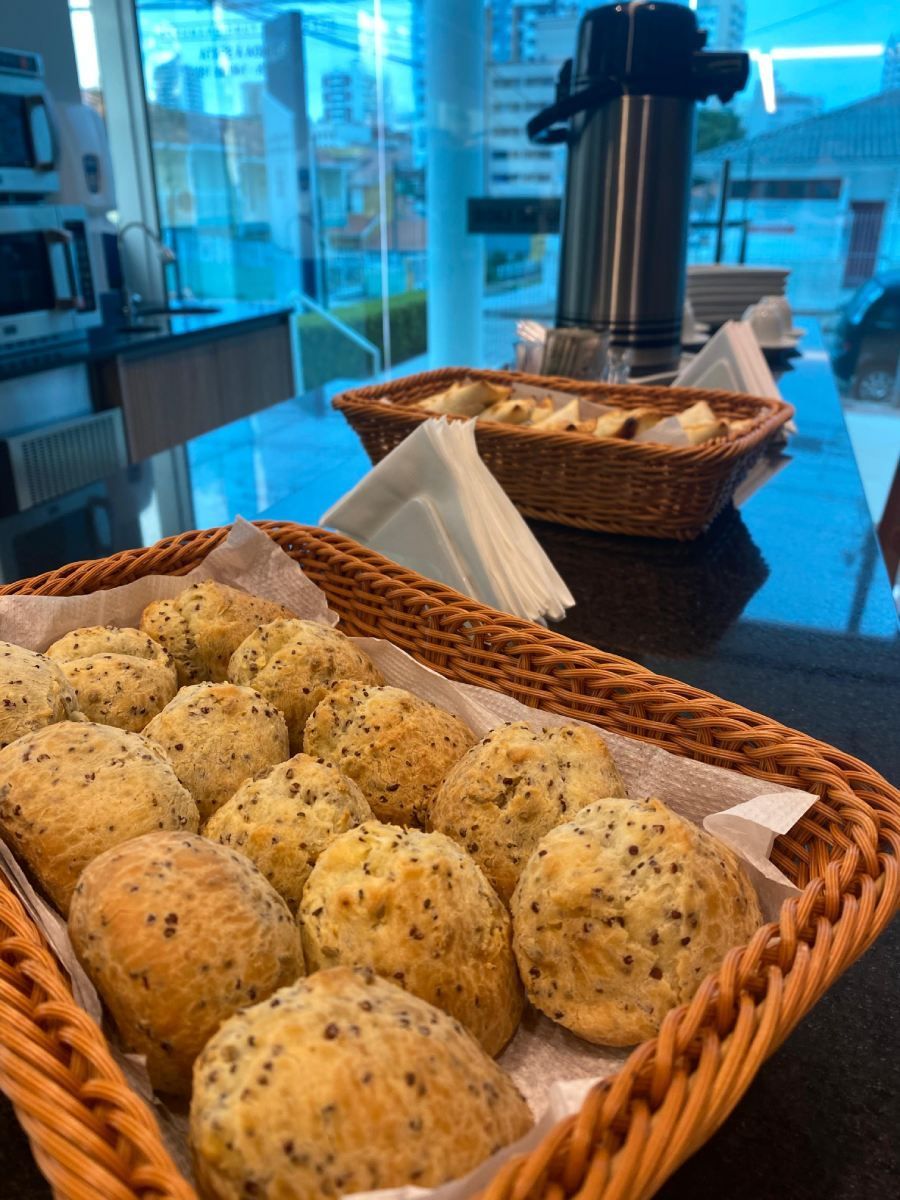 Uma cesta de vime cheia de bolas de pão sobre uma mesa