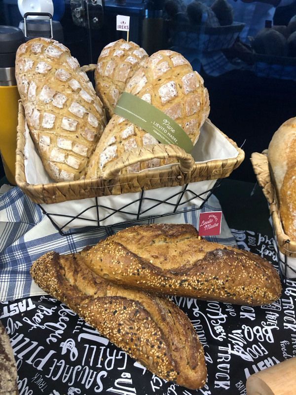 Uma cesta de pães está em cima de uma mesa.