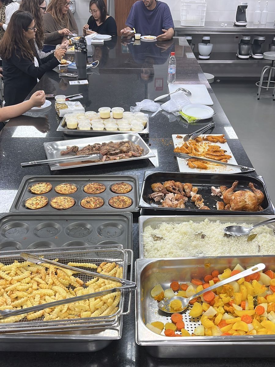 Um grupo de pessoas está sentado à mesa comendo.