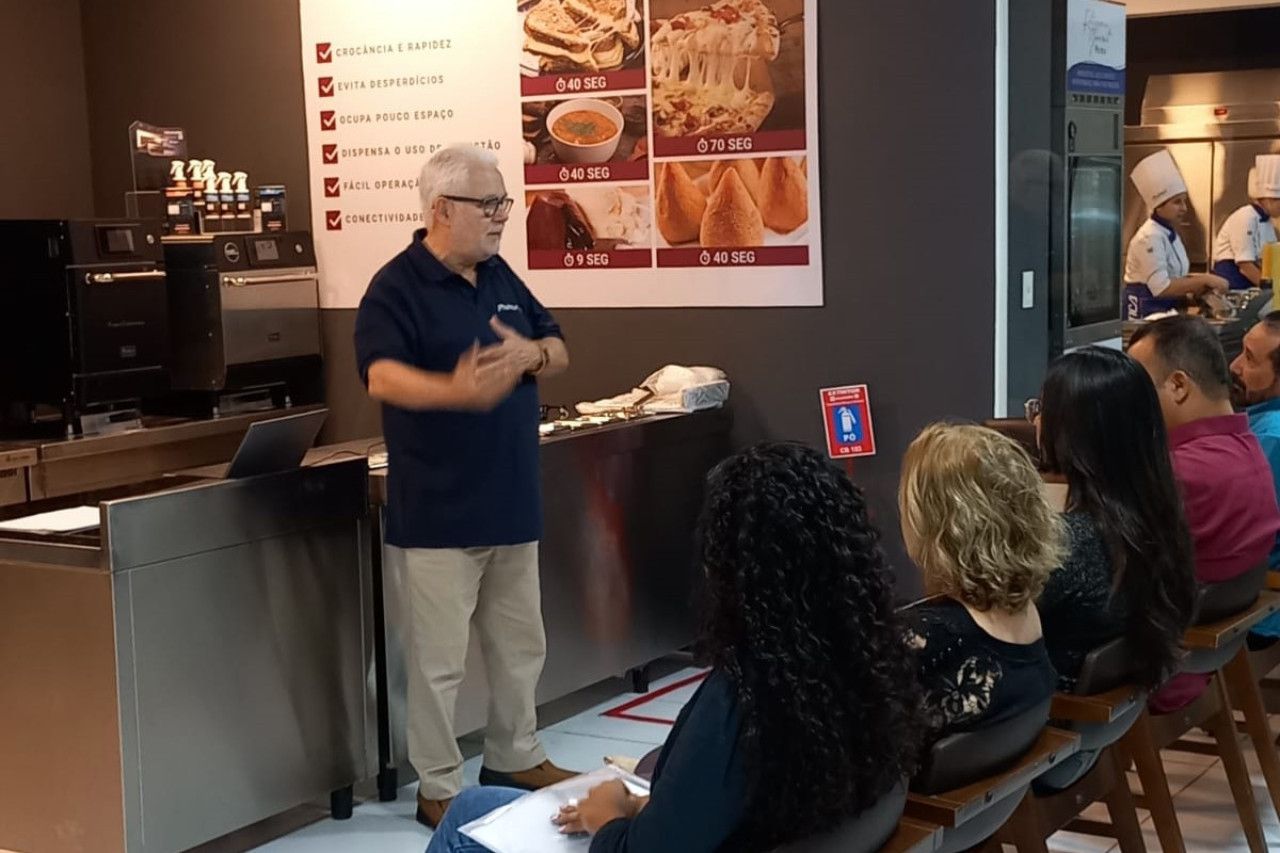 Um homem está fazendo uma apresentação para um grupo de pessoas em um restaurante.