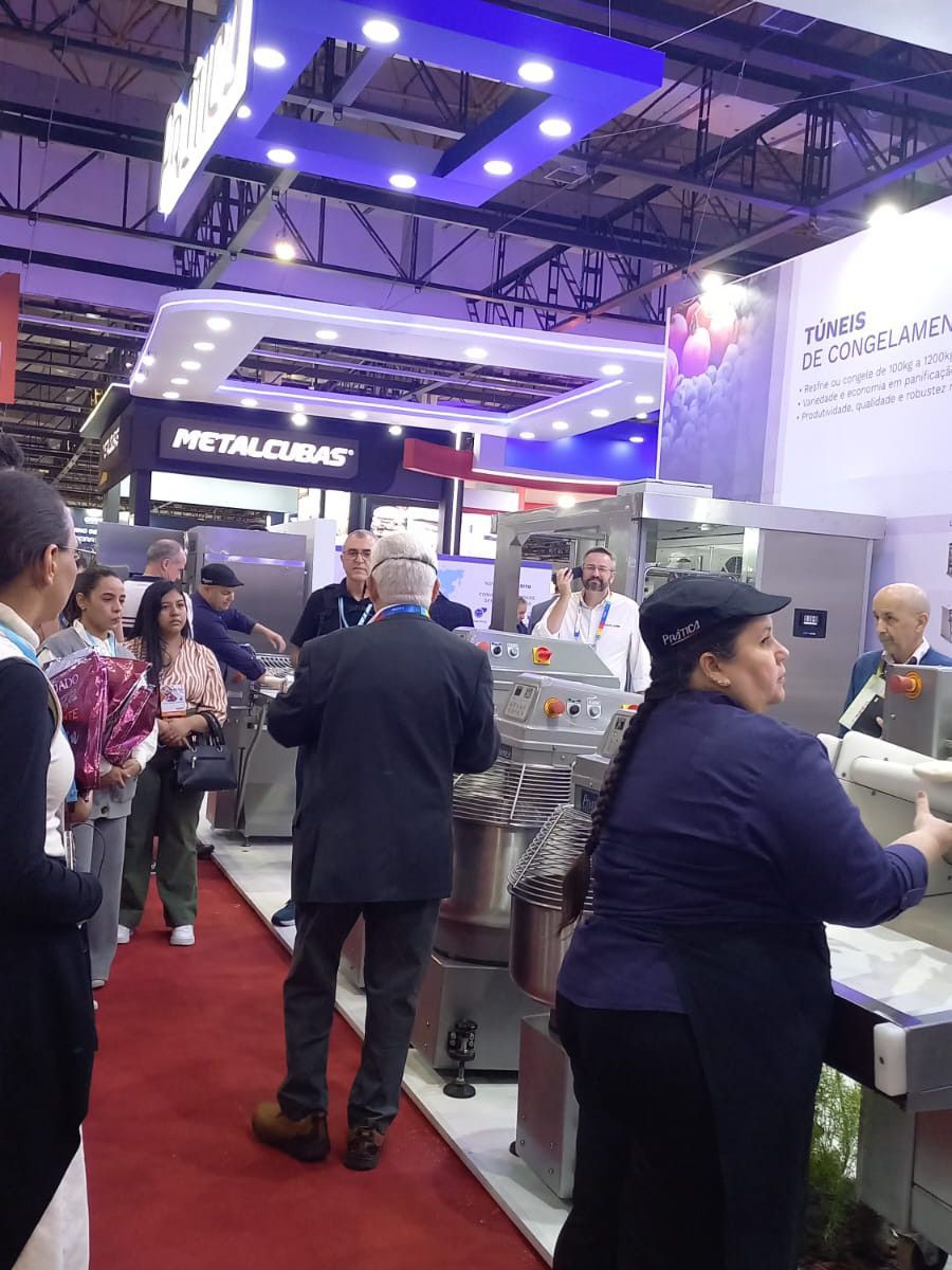 Um grupo de pessoas está em uma sala com tapete vermelho.