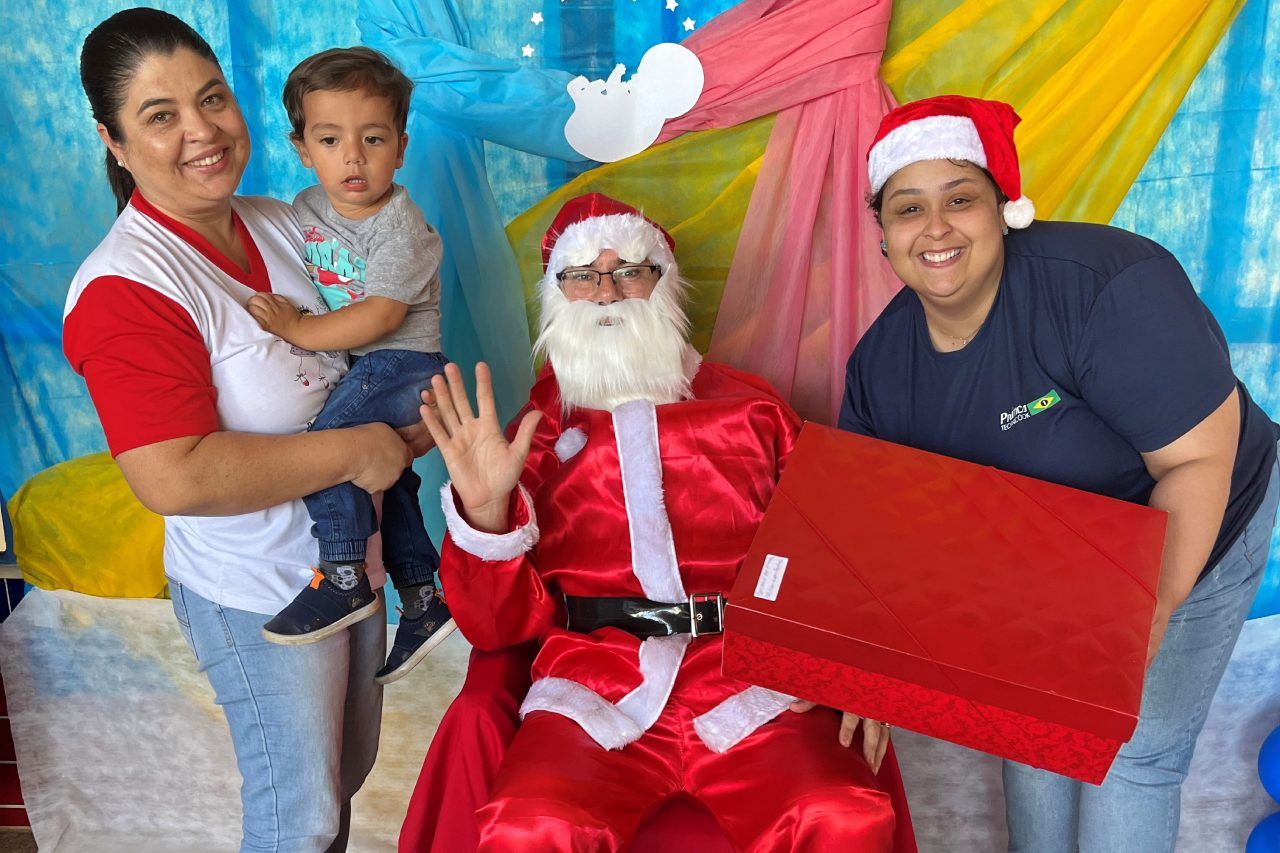 Duas mulheres e uma criança posam para uma foto com o Papai Noel.