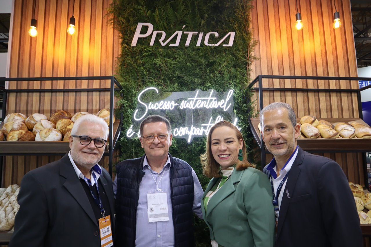 Um grupo de pessoas está posando para uma foto em frente a uma padaria.