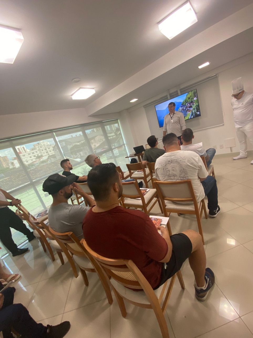 Um grupo de pessoas está sentado em cadeiras em uma sala.