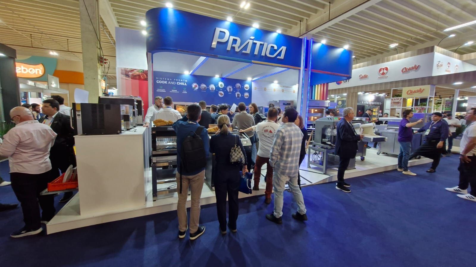 Um grupo de pessoas está em frente a um estande em uma convenção.