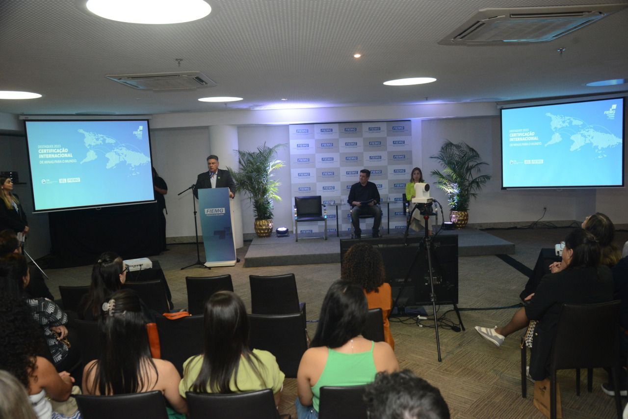 Um grupo de pessoas sentadas em frente a uma tela de projetor