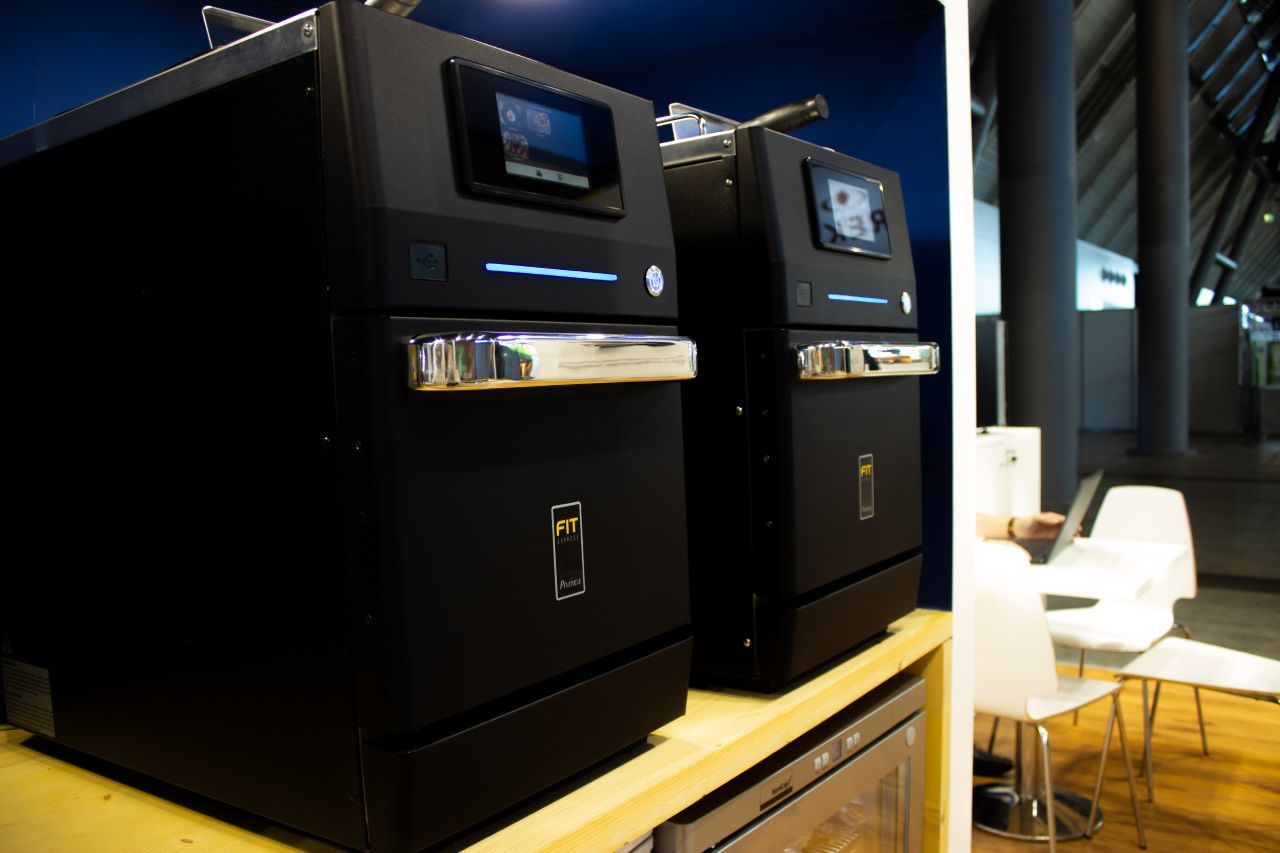 Dois aparelhos pretos estão sobre uma mesa de madeira.