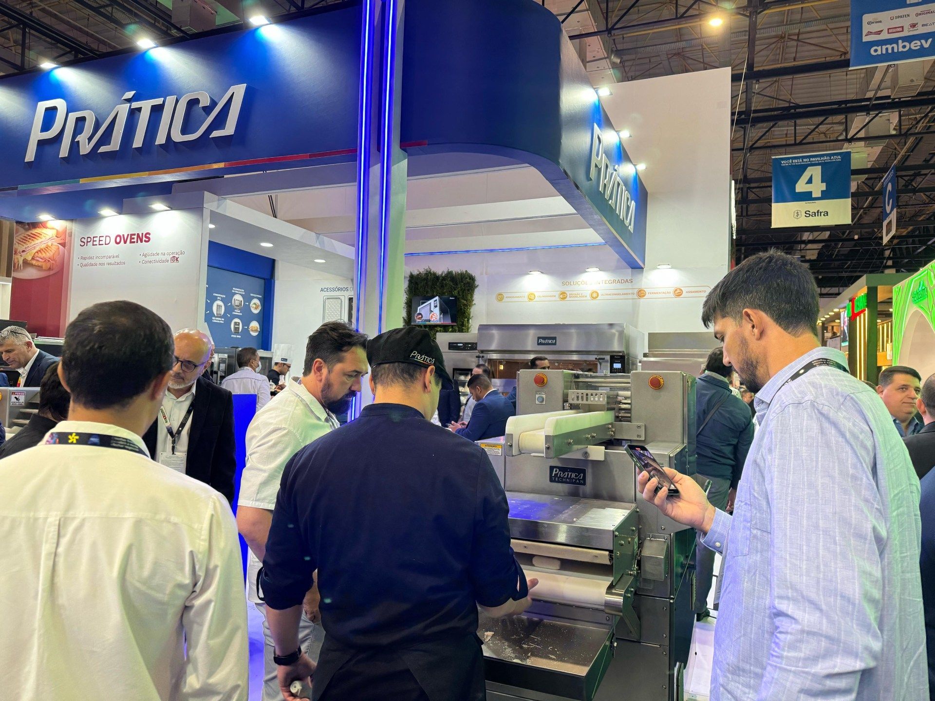 Um grupo de homens está em volta de uma máquina em uma convenção.