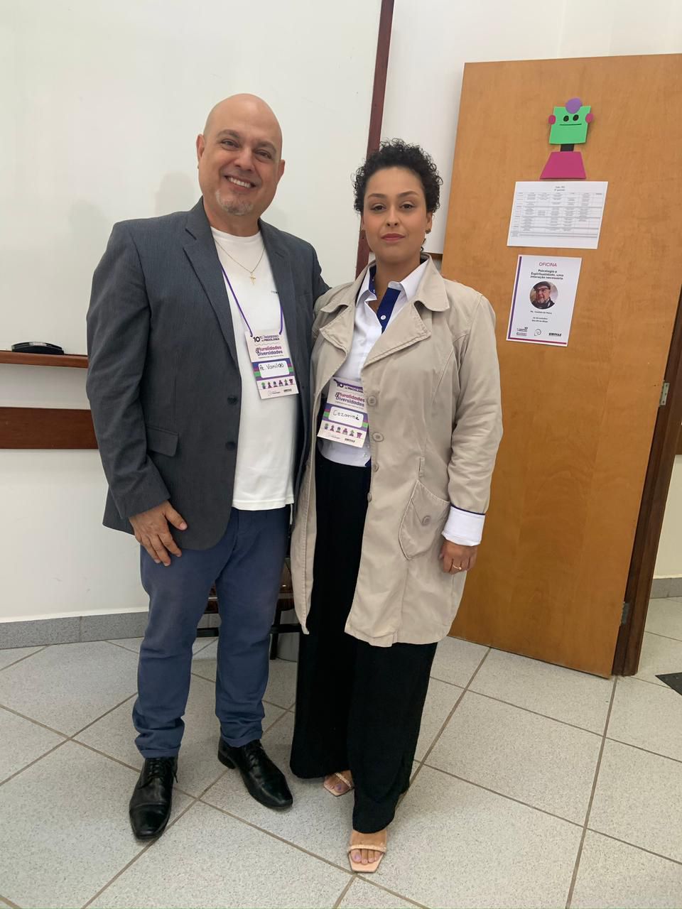 Um homem e uma mulher estão posando para uma foto em uma sala.