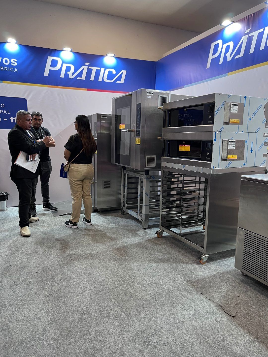 Um grupo de pessoas está em uma sala com eletrodomésticos de aço inoxidável.