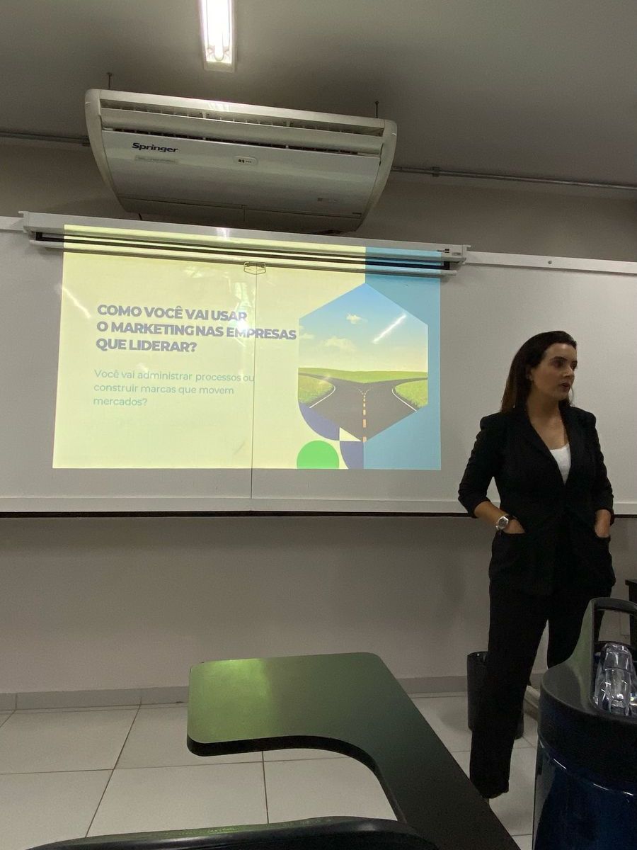 Uma mulher está fazendo uma apresentação em frente a uma tela de projetor.