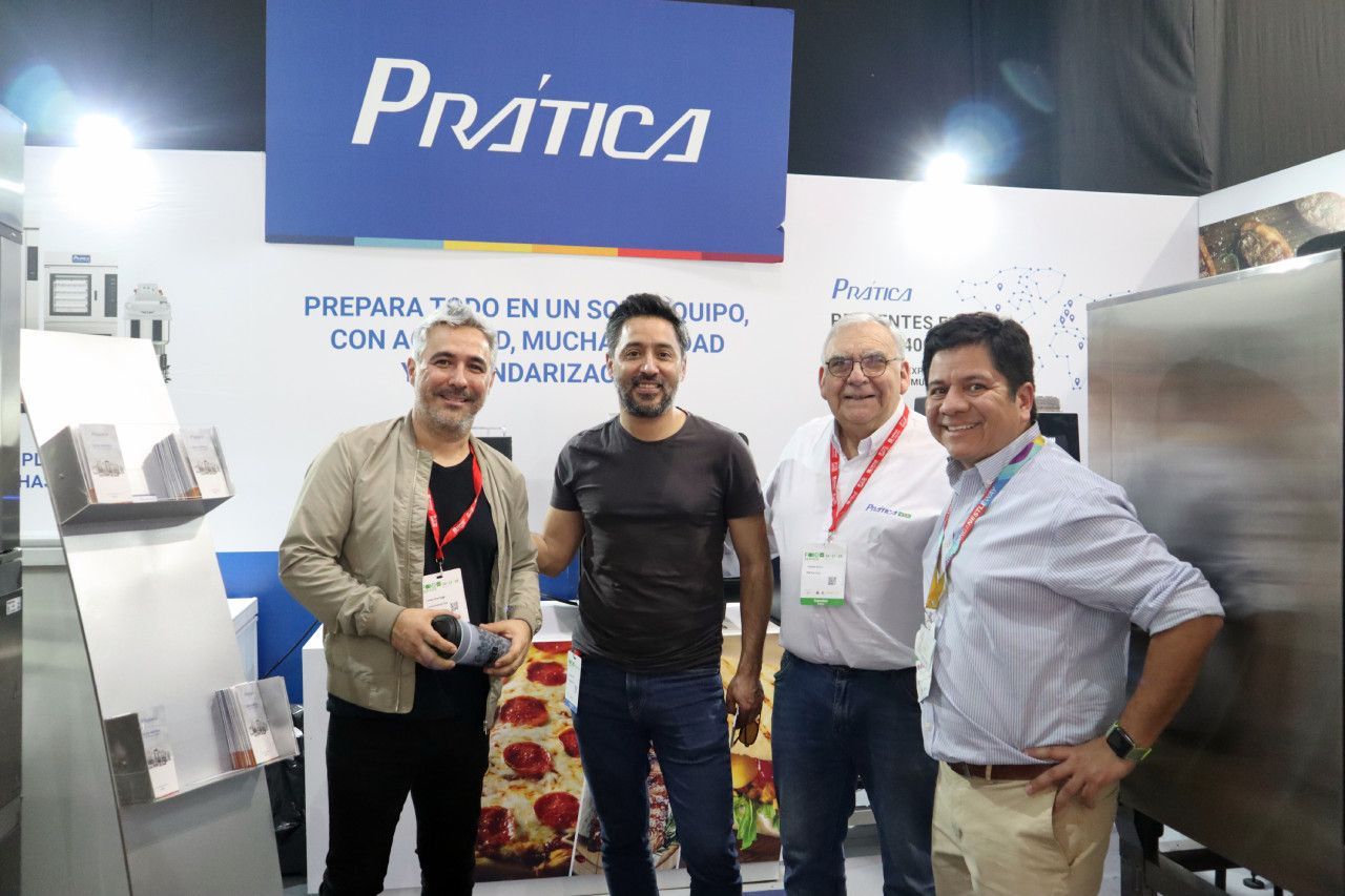 Um grupo de homens está posando para uma foto em frente a uma placa de prática.