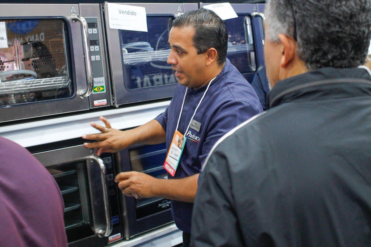 Um homem de camisa azul está olhando para um forno de micro-ondas