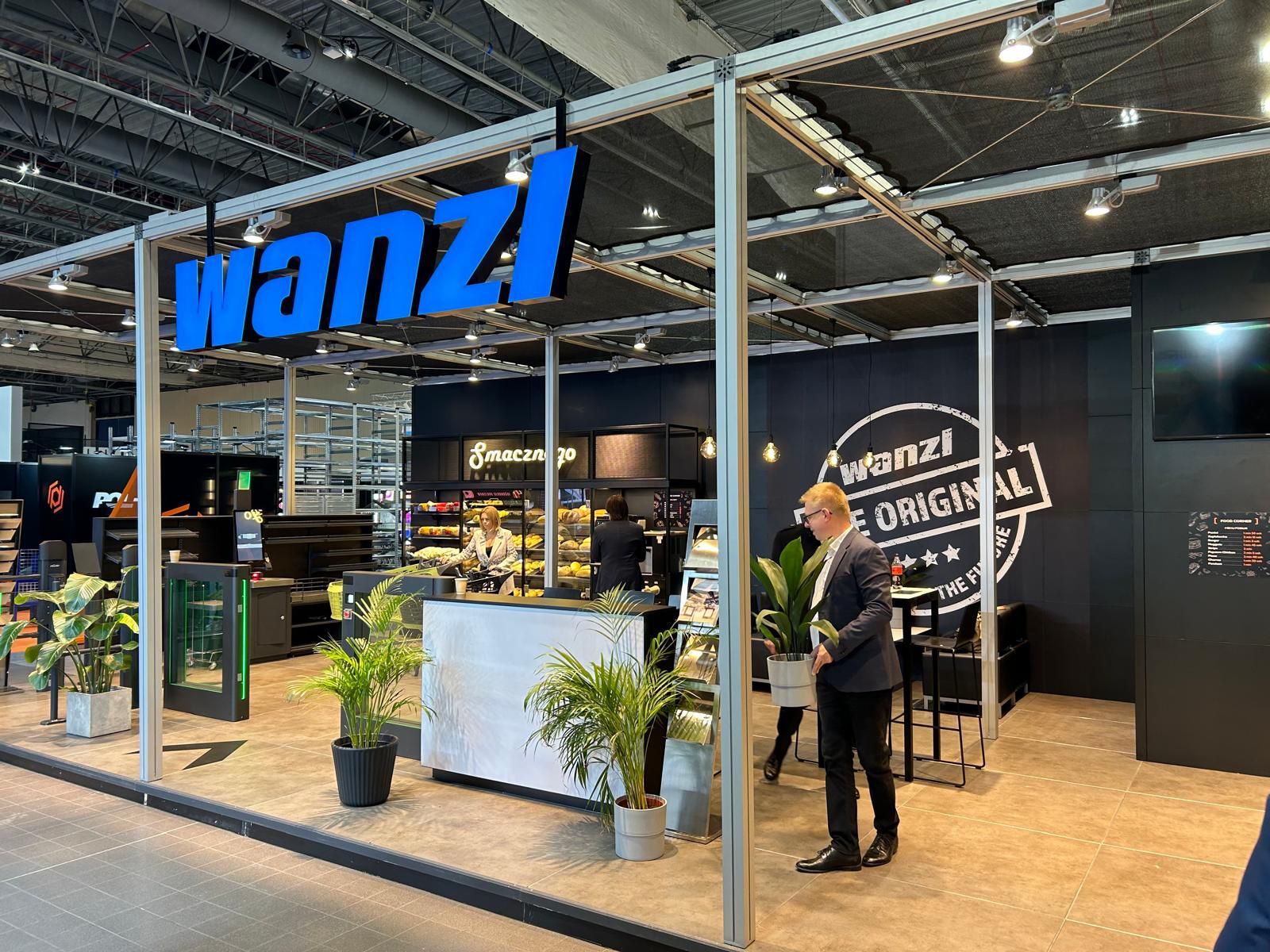 Um homem de terno está parado em frente a uma loja wanzi.