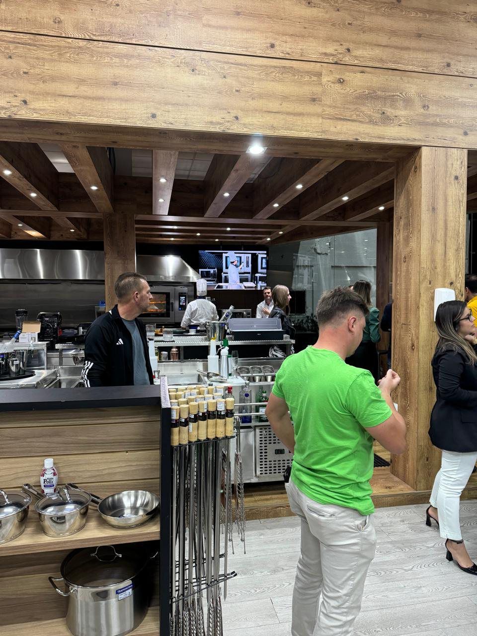 Um homem de camisa verde está parado na cozinha.