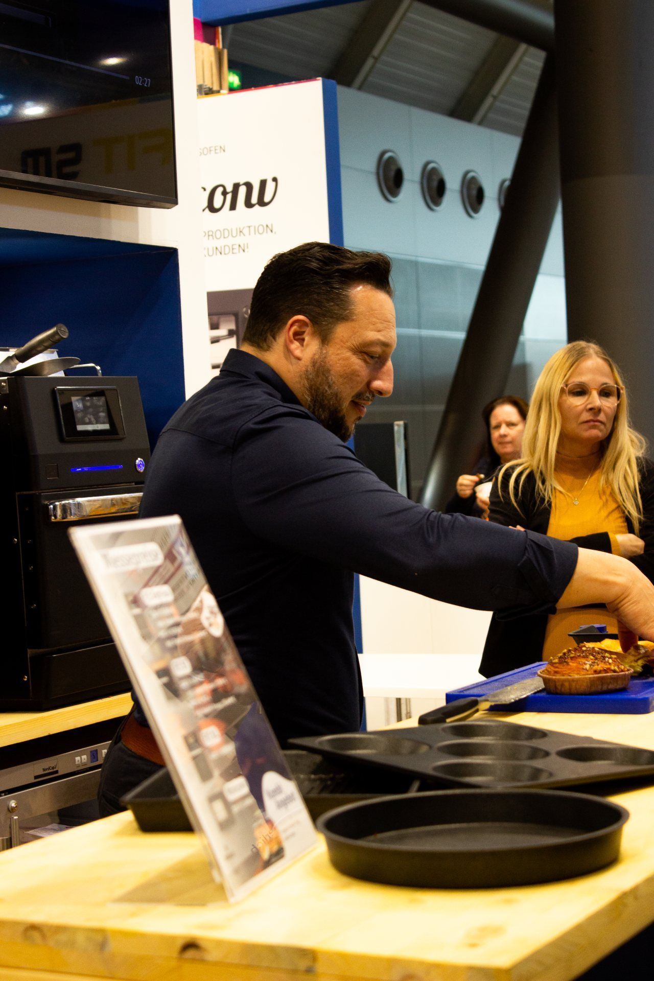 Um homem está de pé em uma mesa preparando comida.