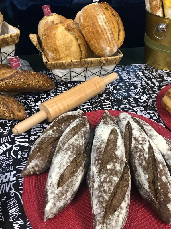 Um monte de pão está sobre uma mesa ao lado de um rolo de massa.