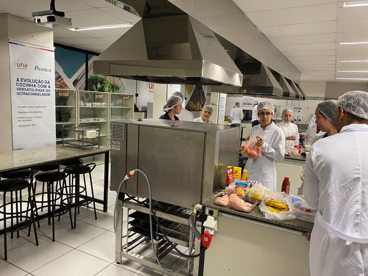 Um grupo de pessoas está em uma cozinha preparando comida.