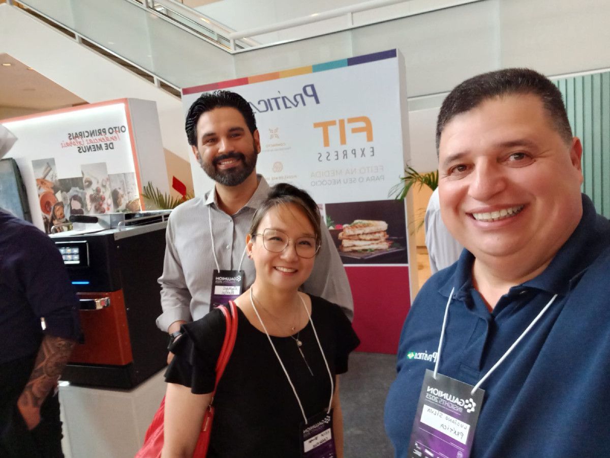 Um grupo de pessoas está posando para uma foto em frente a uma placa que diz tir