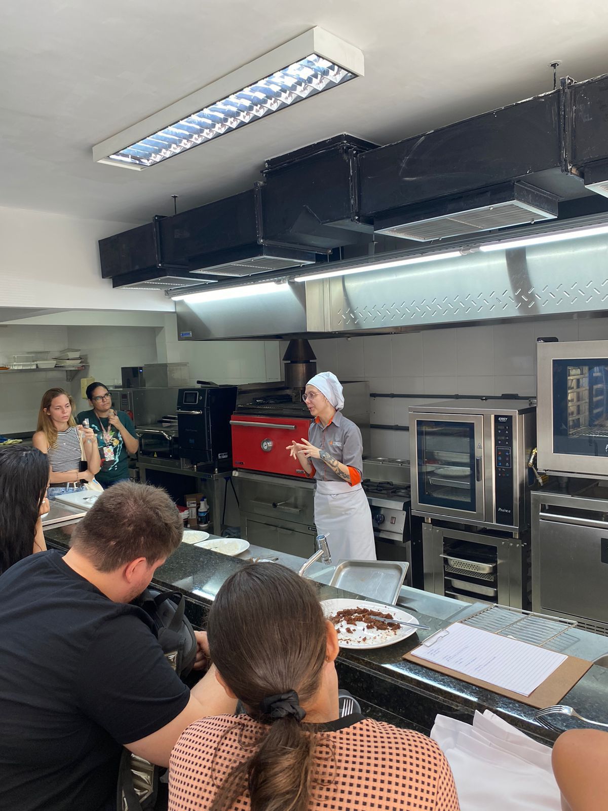 Um grupo de pessoas está sentado à mesa na cozinha.