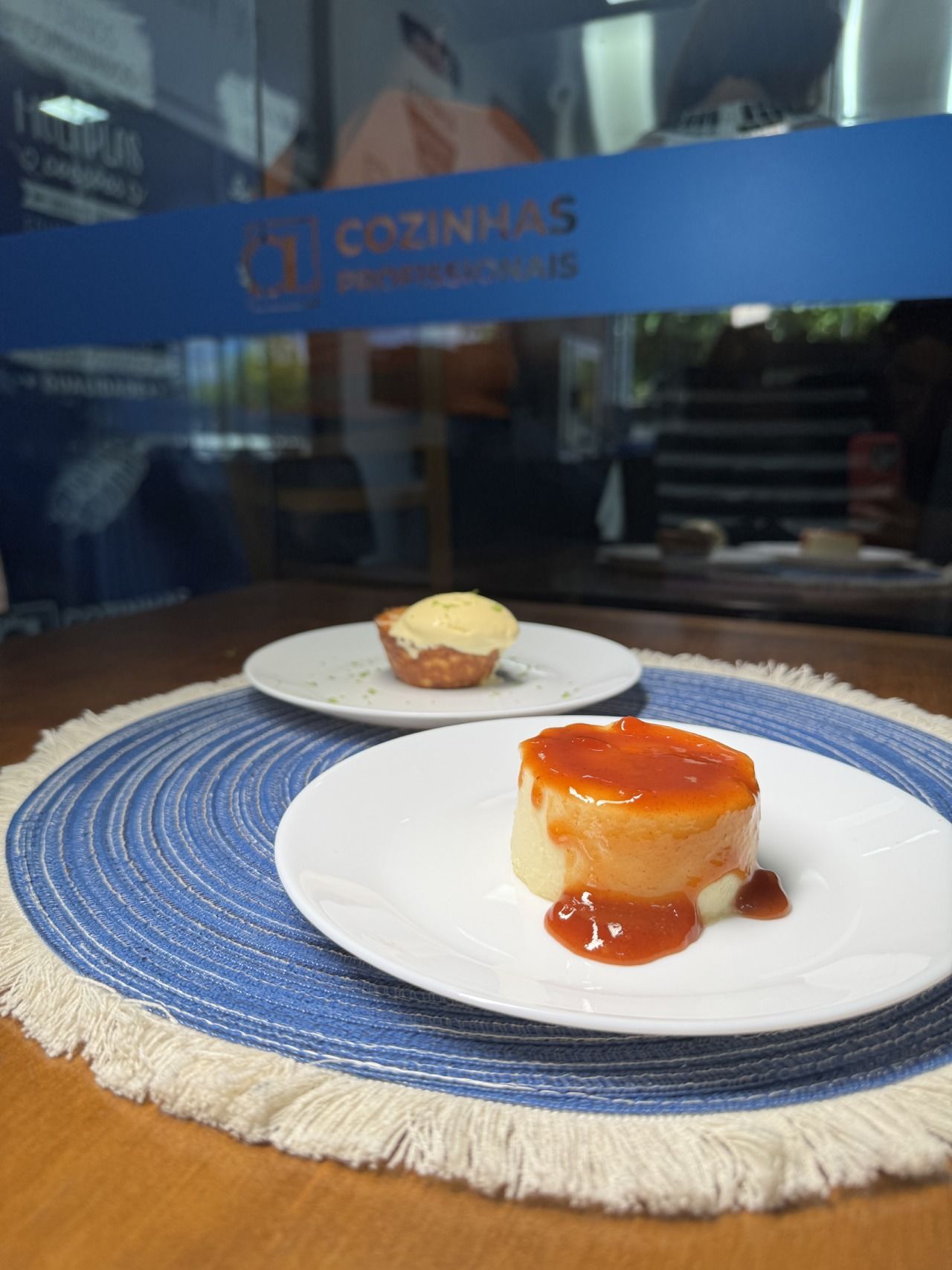 Dois pratos de comida estão sobre um jogo americano em uma mesa.