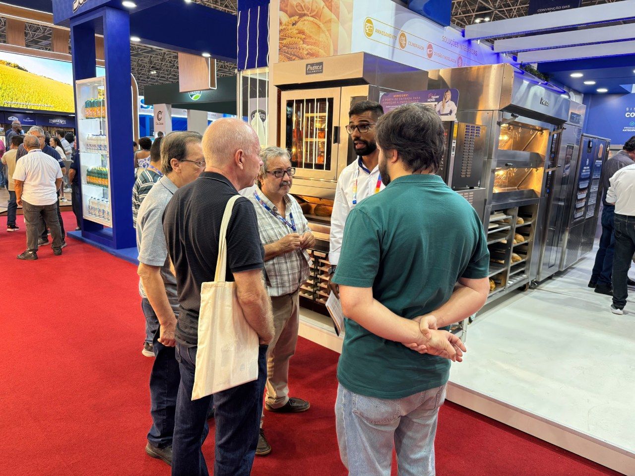 Um grupo de homens está em uma sala conversando entre si.