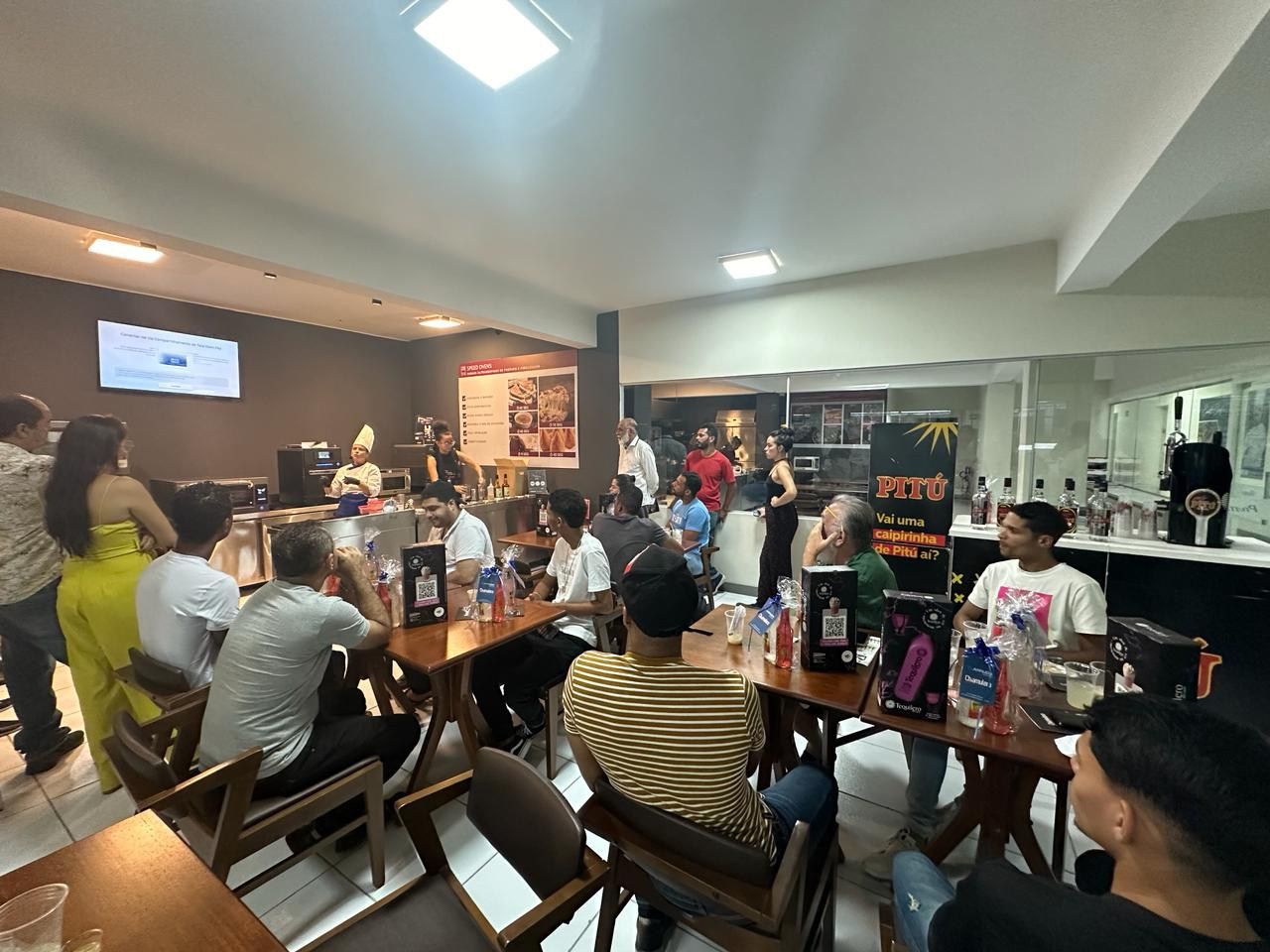 Um grupo de pessoas está sentado em mesas em um restaurante.