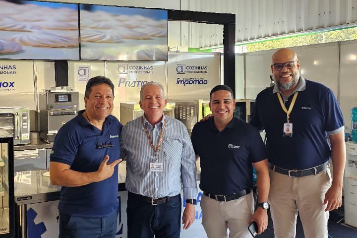Um grupo de homens está posando para uma foto em uma sala.