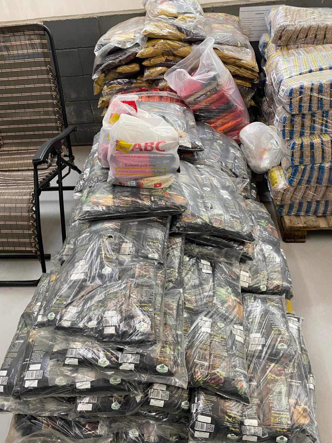 Um monte de sacos de comida empilhados uns sobre os outros sobre uma mesa.