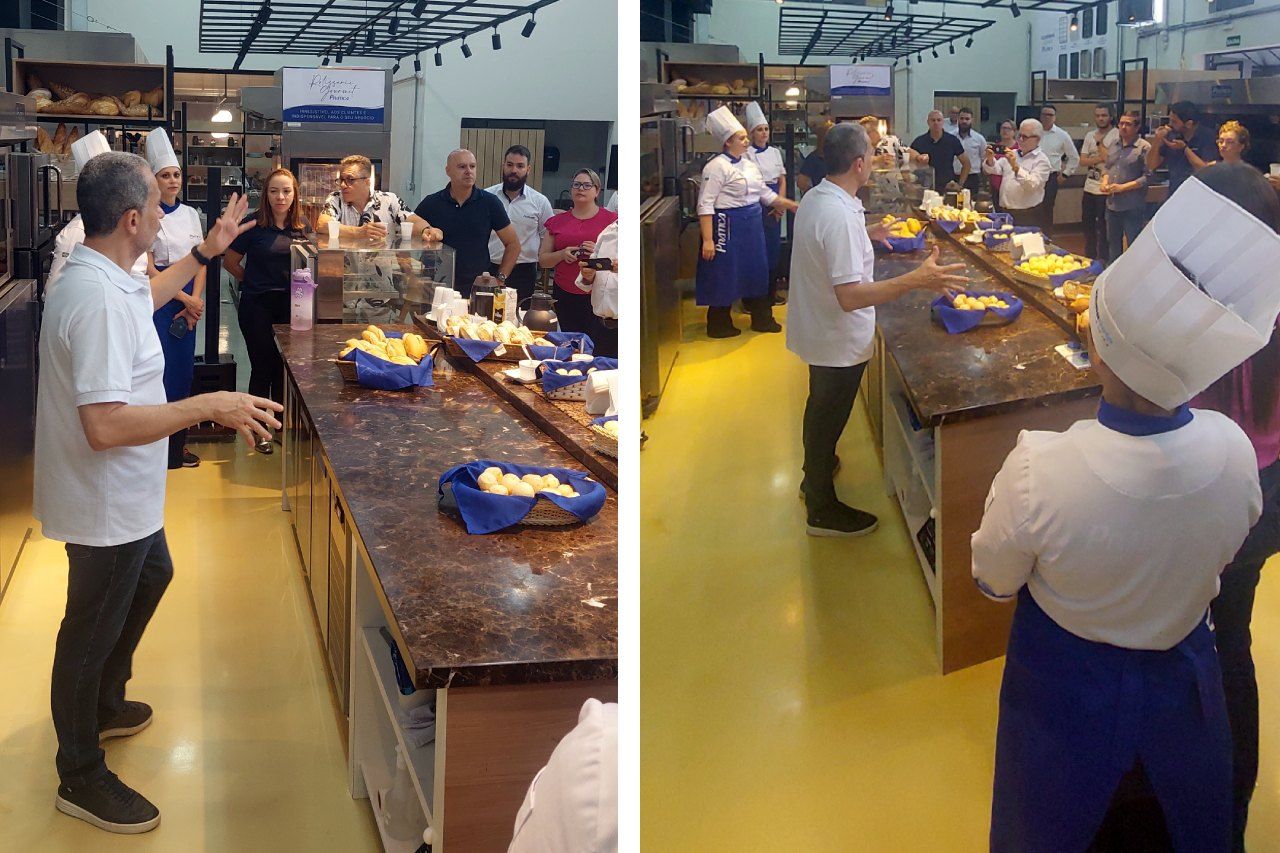 Um grupo de pessoas está em pé ao redor de um balcão na cozinha.