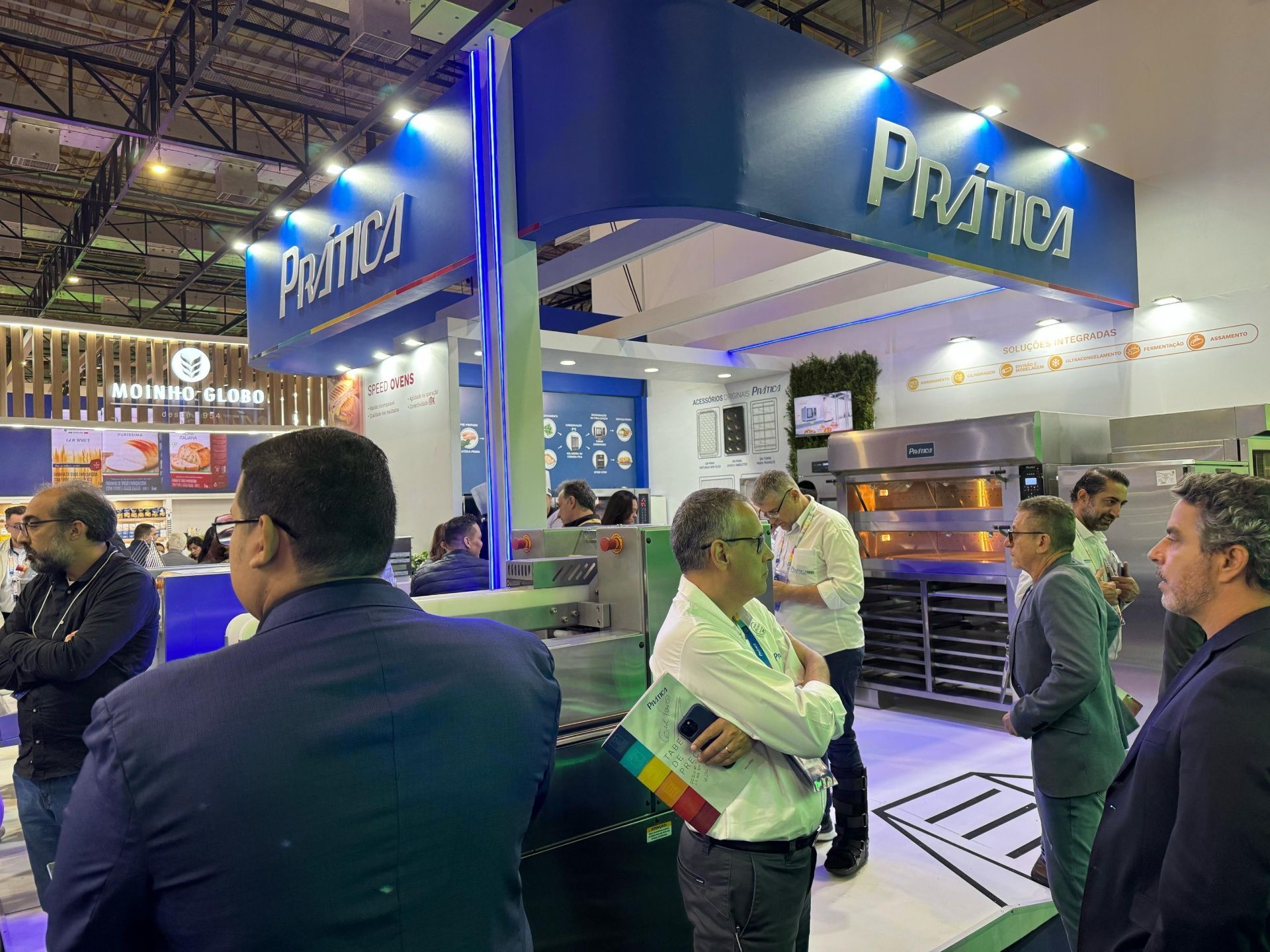 Um grupo de homens está em frente a um estande em uma convenção.